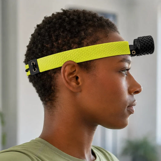 Person wearing a neon-yellow HeadX Duo head-mounted sensor and crosshair laser.